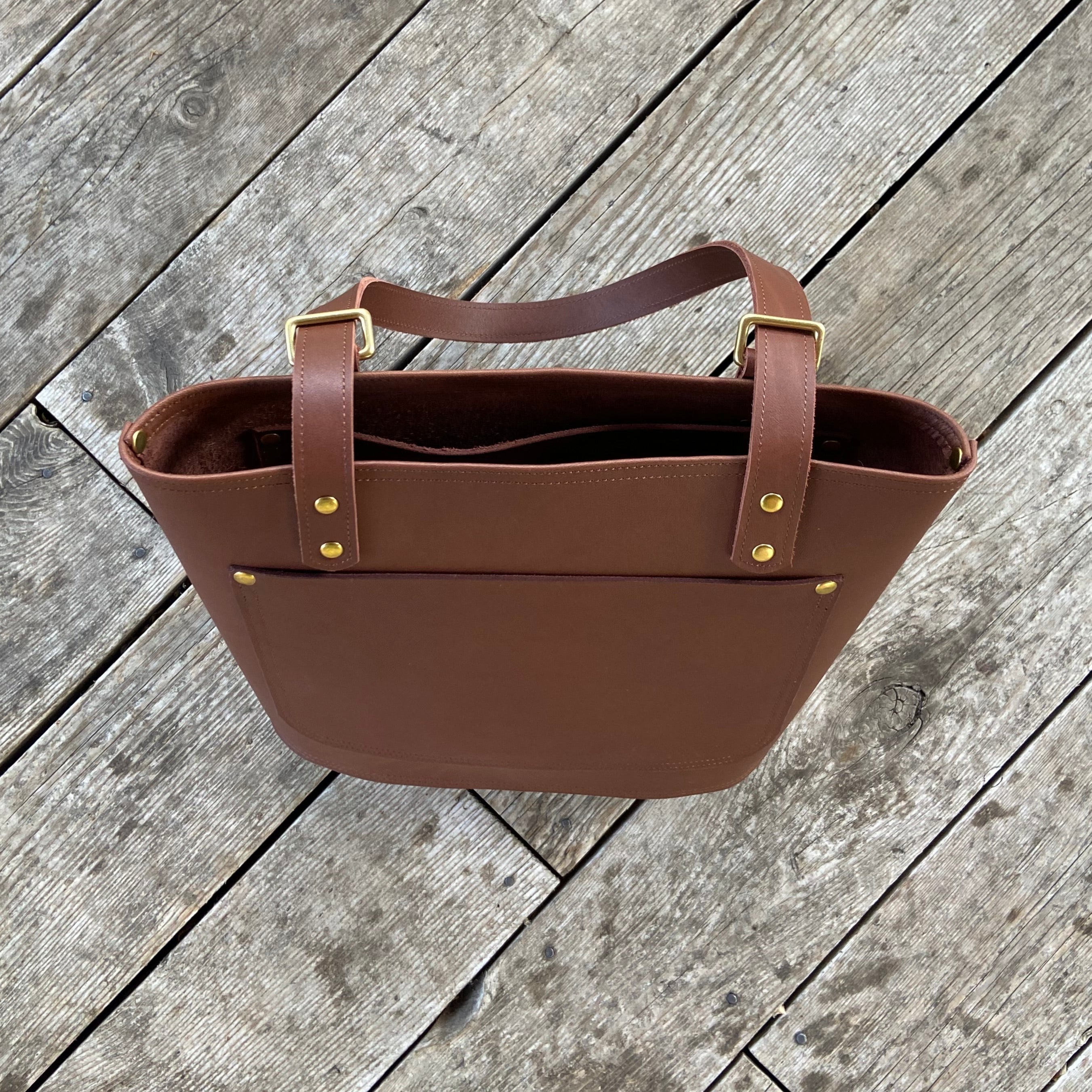 Brown leather bag on a wooden surface